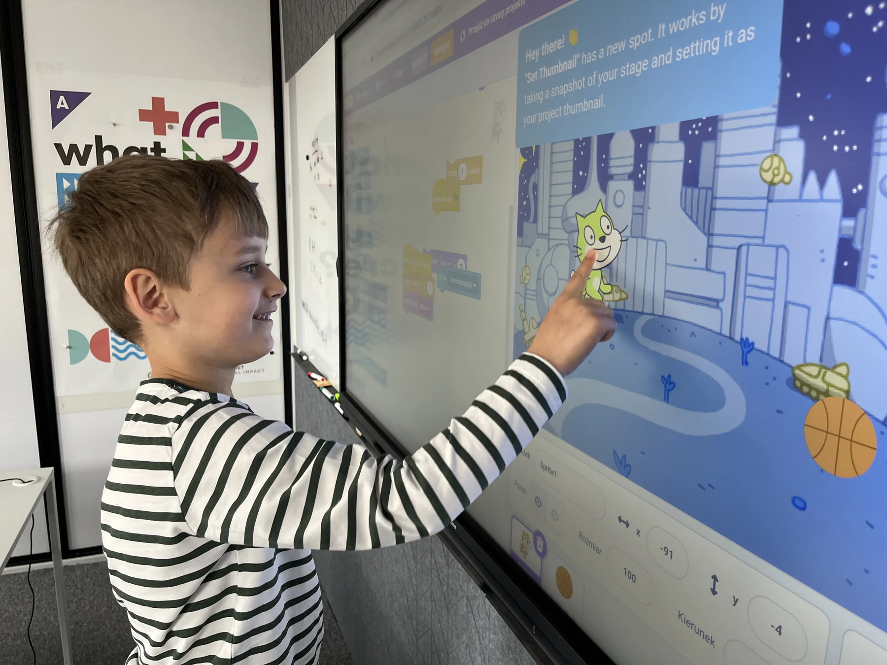Dziecko pracuje przy tablicy interaktywnej w Scratch