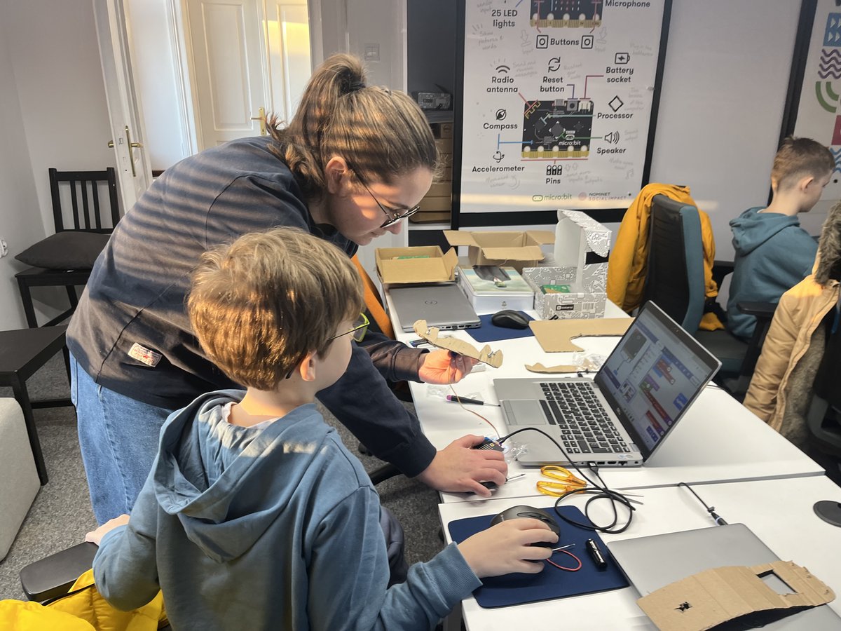 Instruktorka pomaga dziecku budować robota z micro:bit